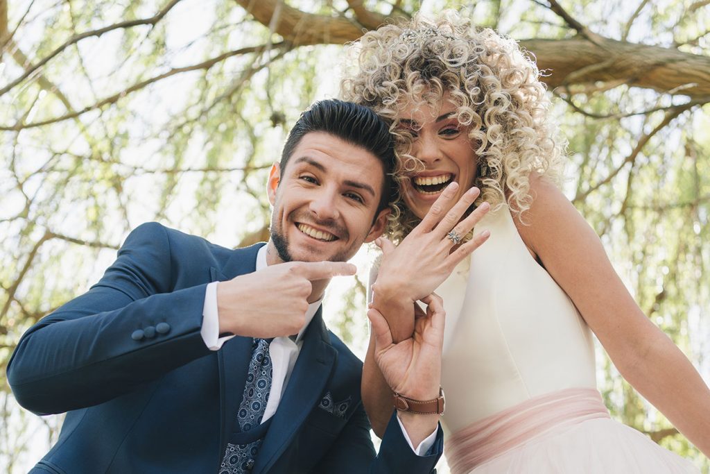 Reportaje de bodas novios enseñando las alianzas muy felices