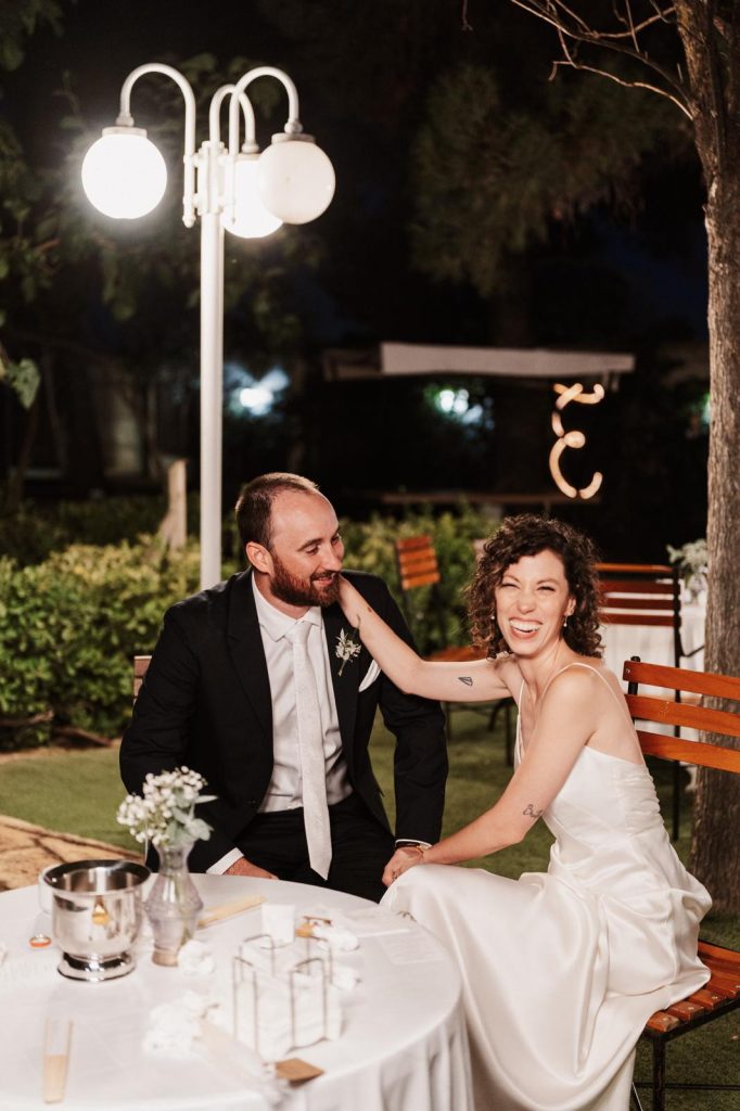 UIna pareja de novios en el banquete de su boda riéndose y pasándolo bien