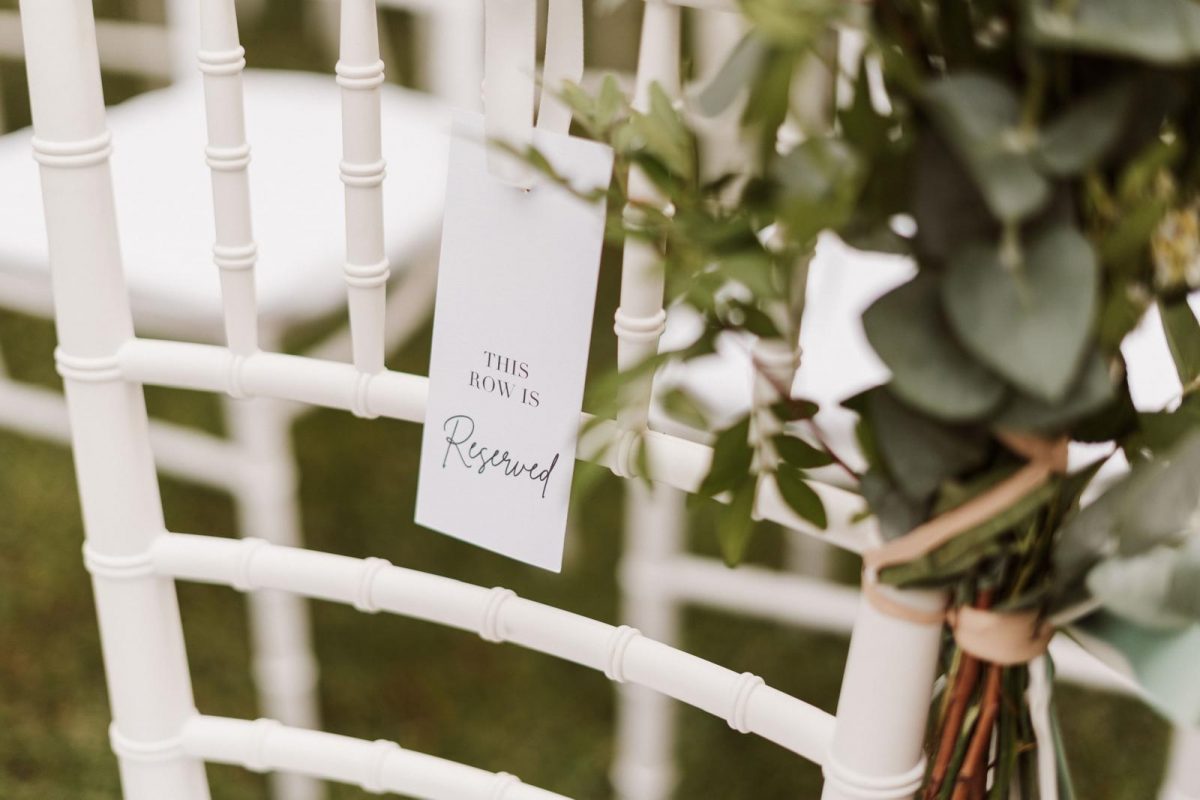 Cartel de sitio reservado en la ceremonia de una boda. Está escrito en inglés