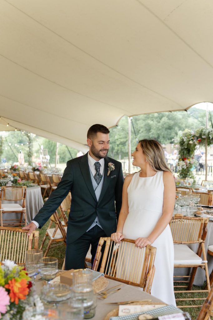 Novios el día de su boda paseando por las mesas del banquete montado al aire libre