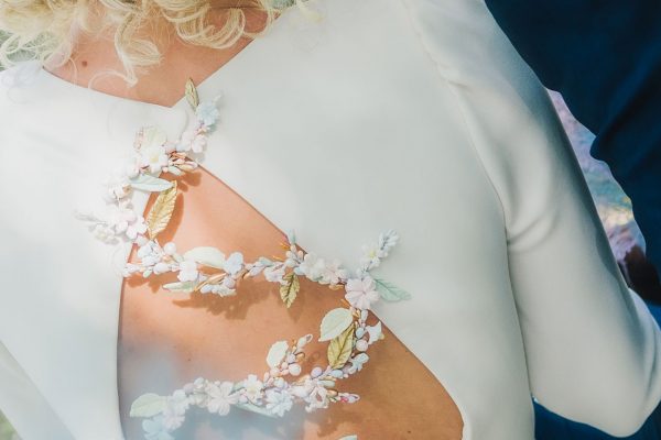 Reportaje de bodas espalda del vestido de la novia con decoración floral
