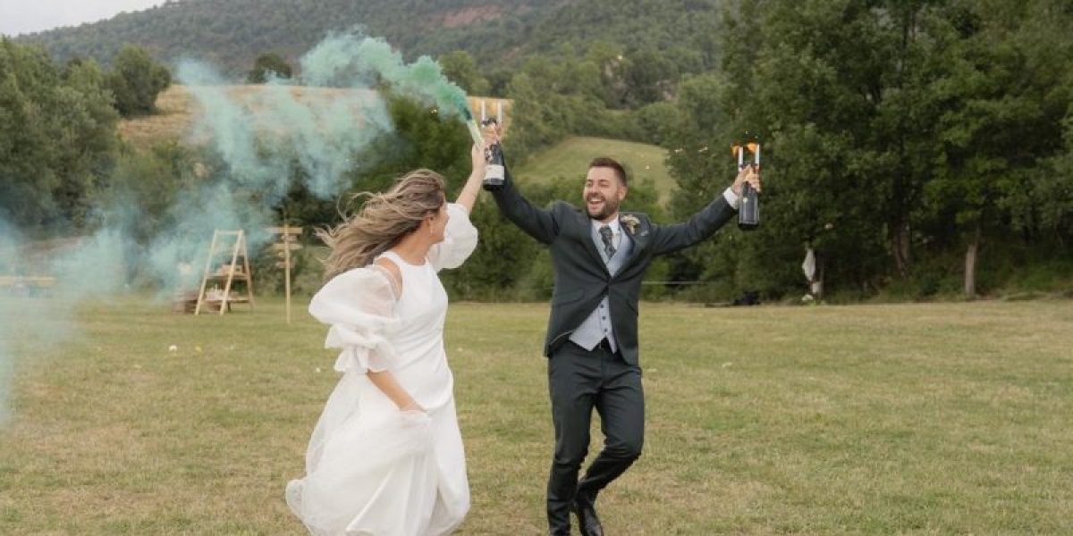 Novios llegando al cóctel con bengalas de humo de colores