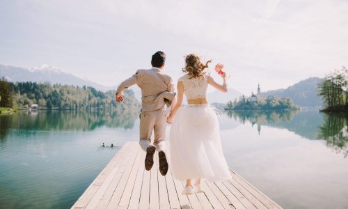 Bodas de destino Europa y novios saltando de felicidad en un muelle tras su boda